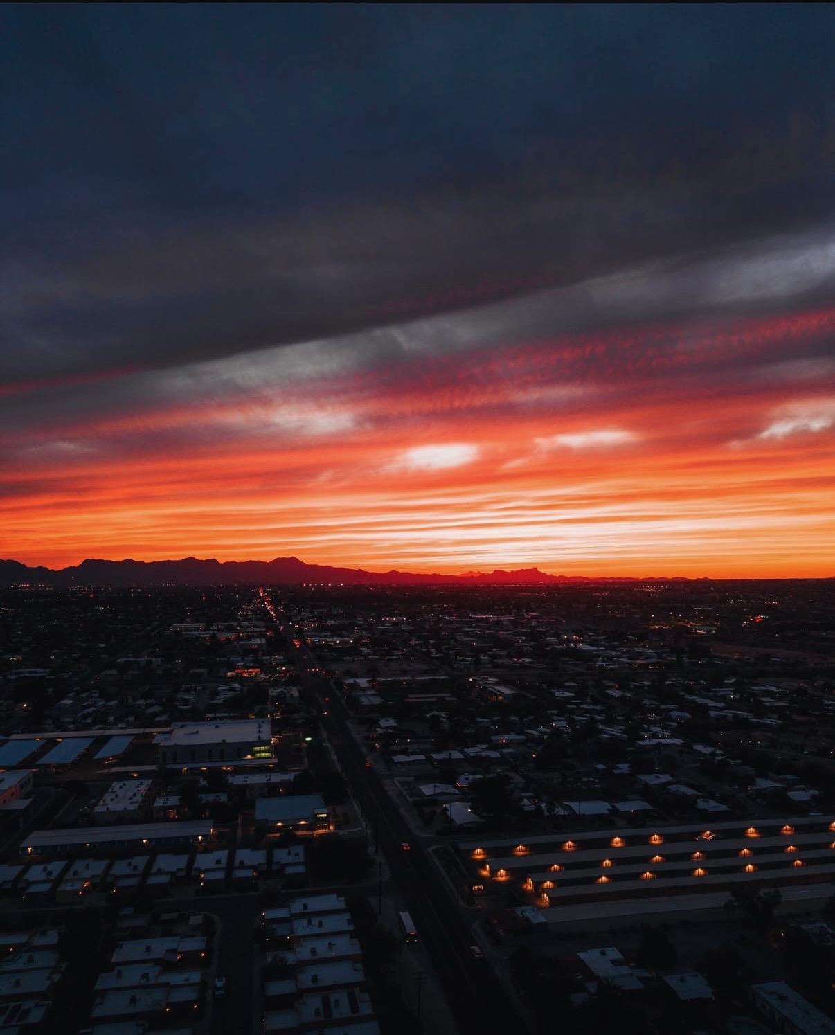 Dramatic aerial sunset over a city skyline